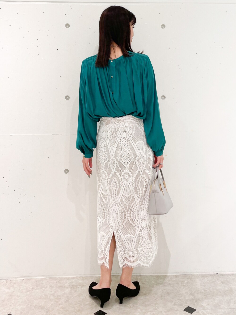 グリーン系のシャツ/ブラウス、ホワイト系のスカート、グレー系のショルダーバッグを着用したレディースの春コーディネートの2枚目の写真