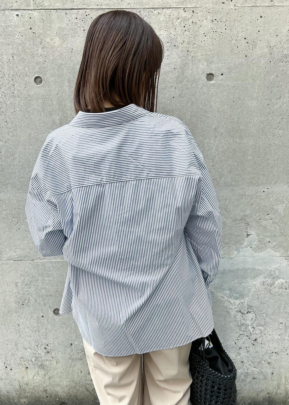 ベージュ系のその他パンツ、ブラック系のトートバッグ、ブルー系のシャツ/ブラウスを着用したレディースの春コーディネートの4枚目の写真