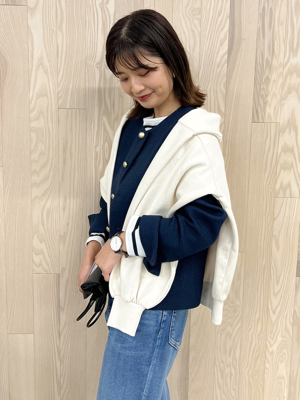 ブルー系のノーカラージャケット、ブラック系のトートバッグ、ホワイト系のTシャツ/カットソーを着用したレディースの春コーディネートの2枚目の写真