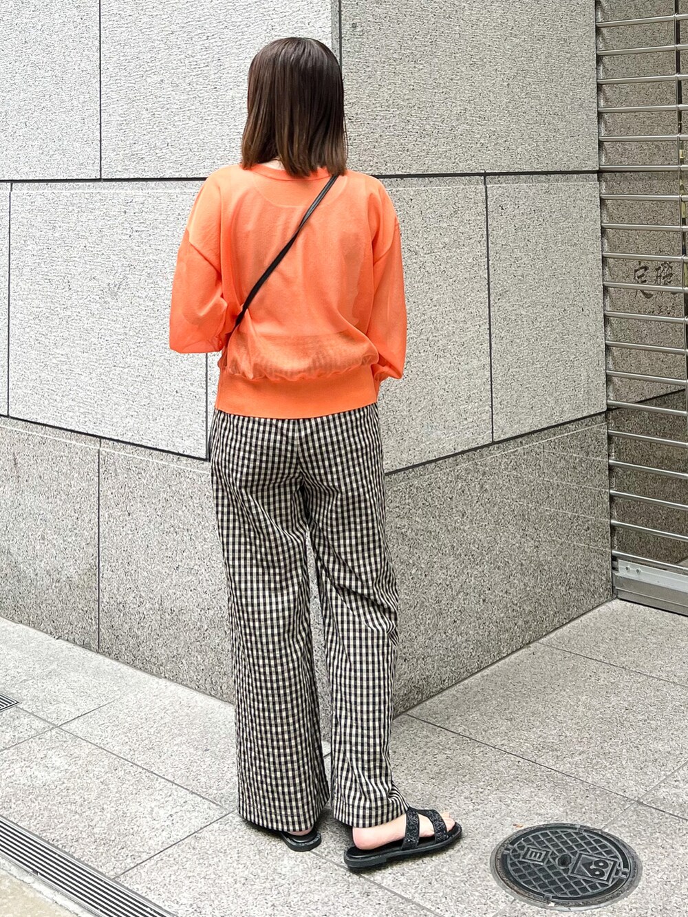 オレンジ系のカーディガン/ボレロ、ブラック系のショルダーバッグ、ブラウン系のその他パンツを着用したレディースの春コーディネートの2枚目の写真