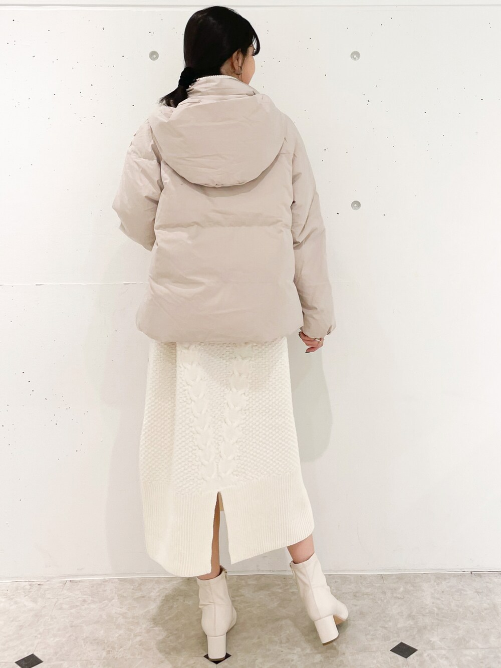 ホワイト系のワンピース、ベージュ系のダウンジャケット/コートを着用したレディースの冬コーディネートの2枚目の写真