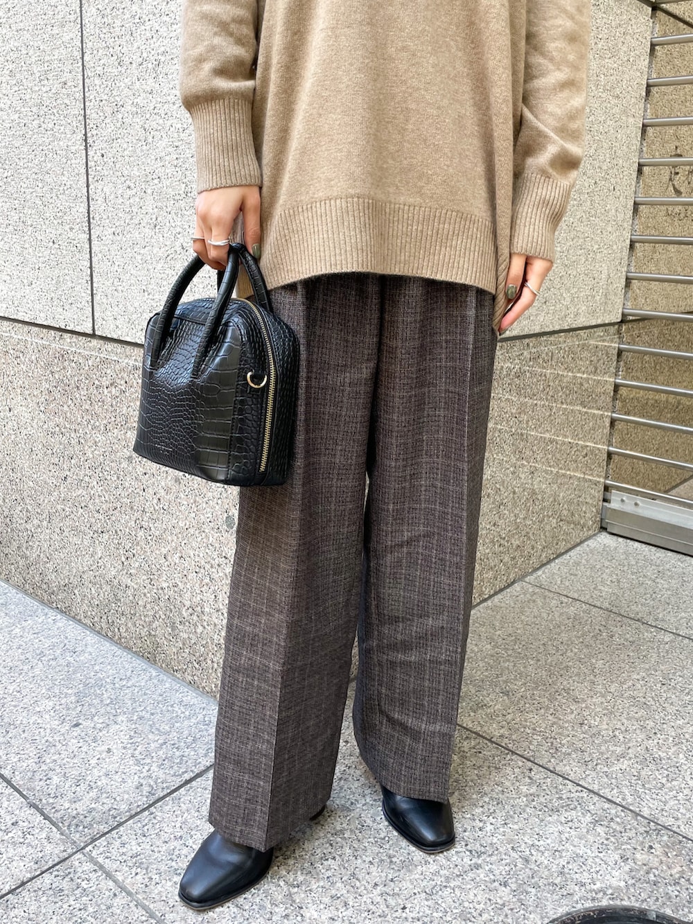 ブラウン系のニット/セーター、ブラック系のその他パンツ、ブラック系のショルダーバッグを着用したレディースの冬コーディネートの5枚目の写真