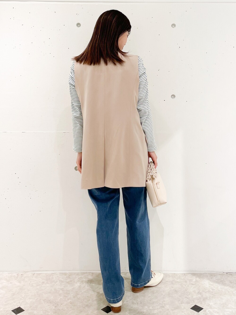 ホワイト系のTシャツ/カットソー、ベージュ系のテーラードジャケット、ブルー系のデニムパンツを着用したレディースの春コーディネートの2枚目の写真
