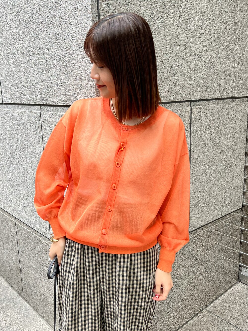 オレンジ系のカーディガン/ボレロ、ブラック系のショルダーバッグ、ブラウン系のその他パンツを着用したレディースの春コーディネートの3枚目の写真