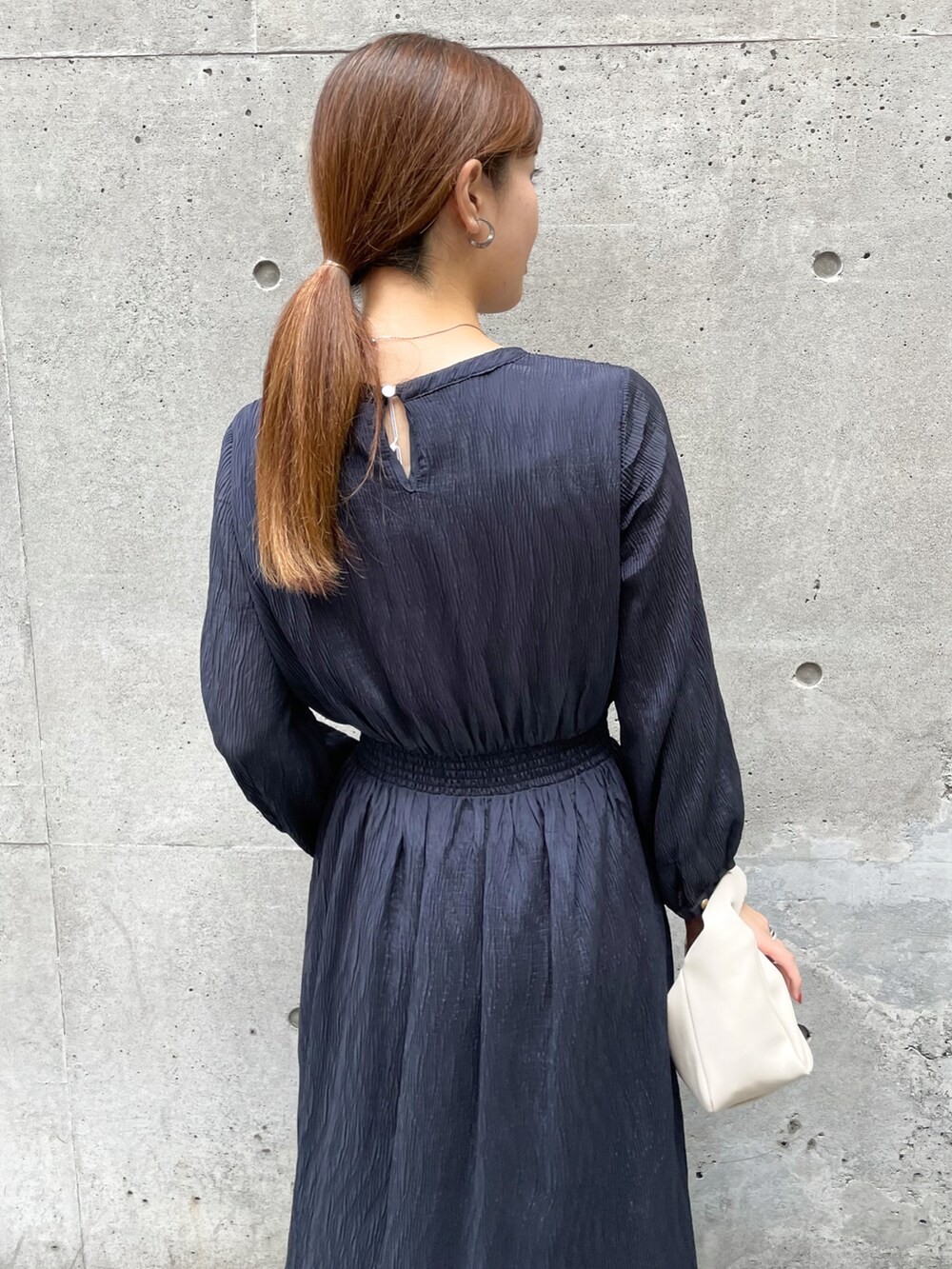 ブルー系のワンピース、ホワイト系のショルダーバッグ、ホワイト系のブーツを着用したレディースの秋コーディネートの5枚目の写真