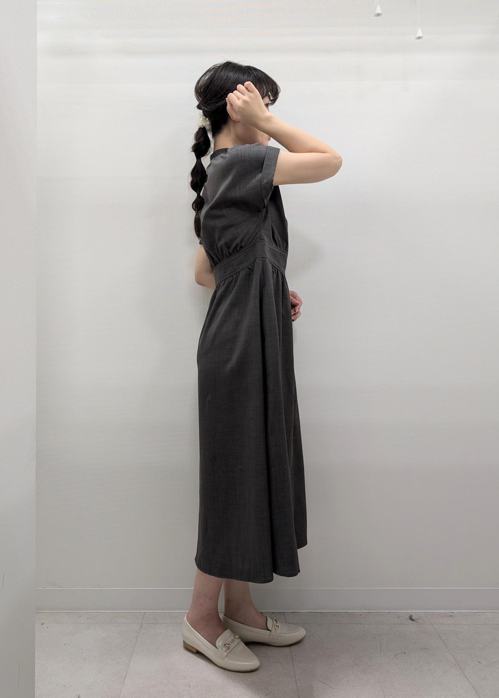 グレー系のワンピース、ホワイト系のパンプス、ホワイト系のトートバッグを着用したレディースの夏コーディネートの3枚目の写真