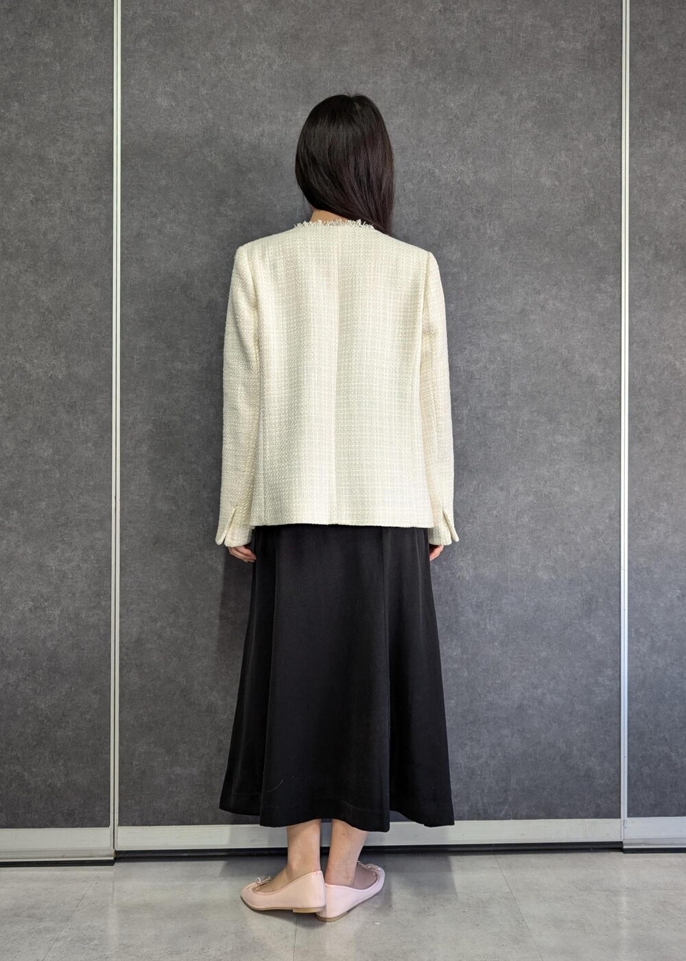 ホワイト系のTシャツ/カットソー、ブラック系のドレス、ホワイト系のノーカラージャケットを着用したレディースの冬コーディネートの4枚目の写真