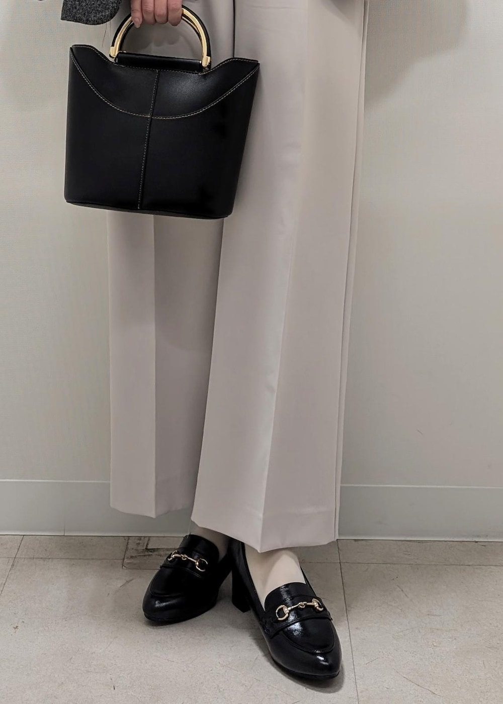 ホワイト系のニット/セーター、ブラック系のテーラードジャケット、ブラック系のショルダーバッグを着用したレディースの冬コーディネートの9枚目の写真