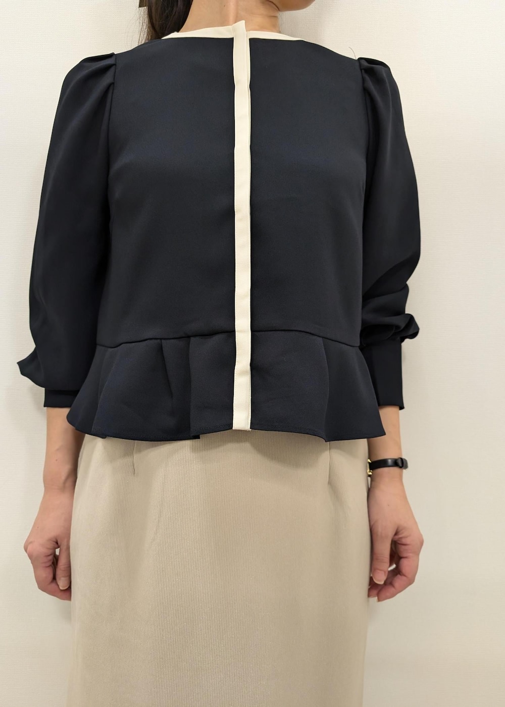 ベージュ系のスカート、ホワイト系のトートバッグ、ブラック系のパンプスを着用したレディースの秋コーディネートの6枚目の写真