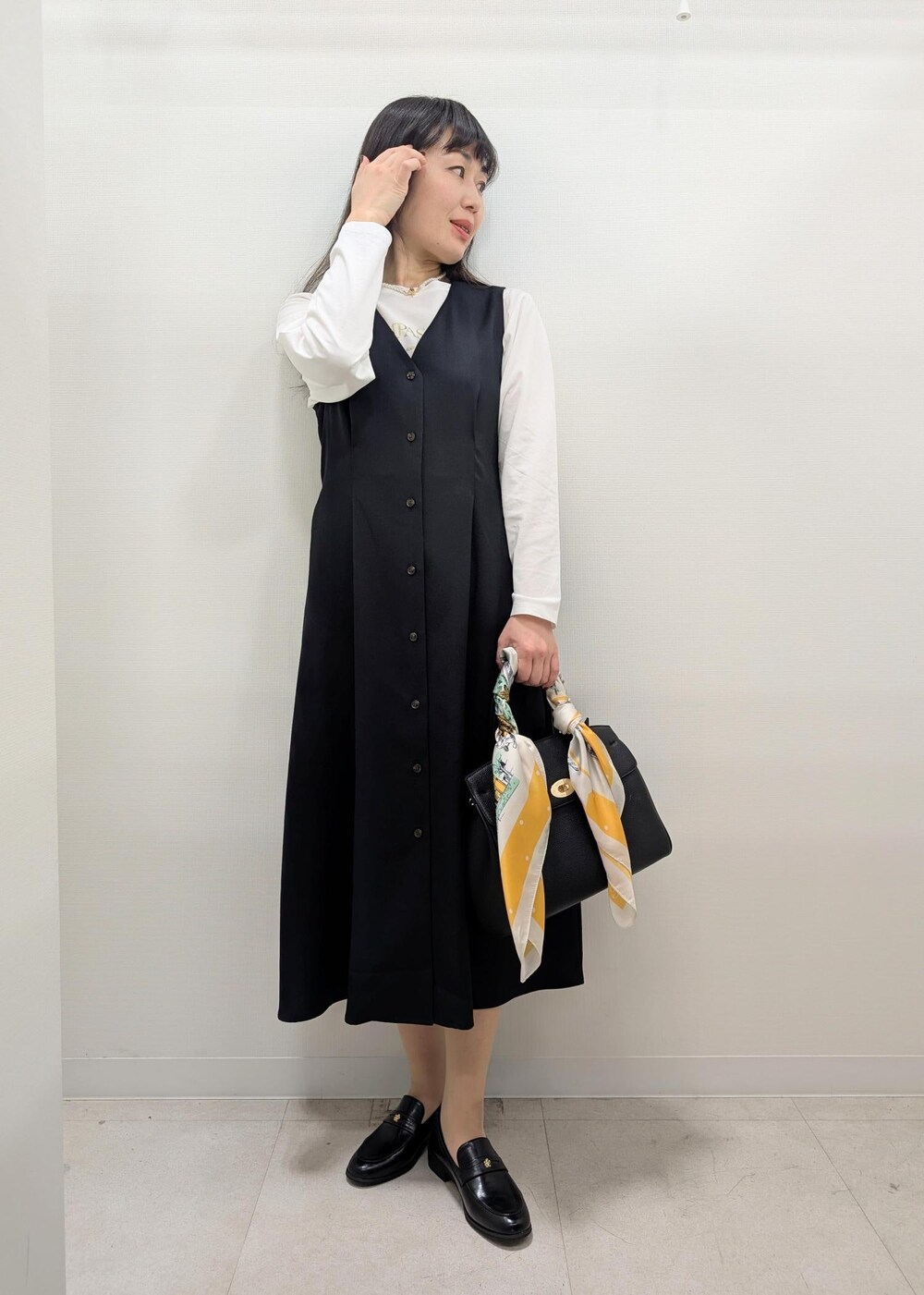 ブラック系のローファー、ブラック系のトートバッグ、ホワイト系のカーディガン/ボレロを着用したレディースの春コーディネートの5枚目の写真