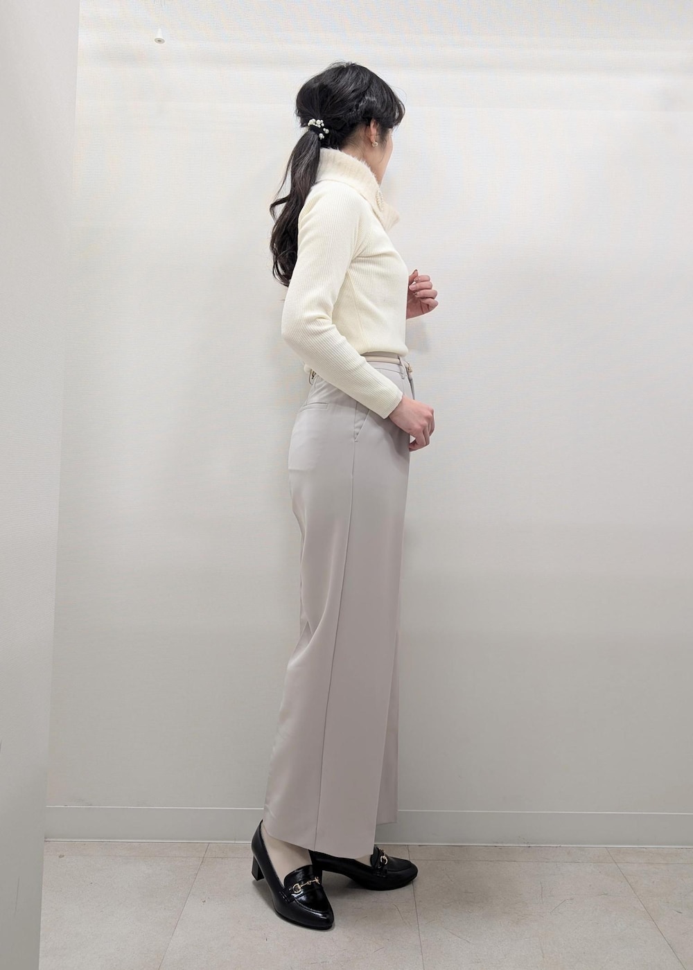 ホワイト系のニット/セーター、ブラック系のテーラードジャケット、ブラック系のショルダーバッグを着用したレディースの冬コーディネートの6枚目の写真