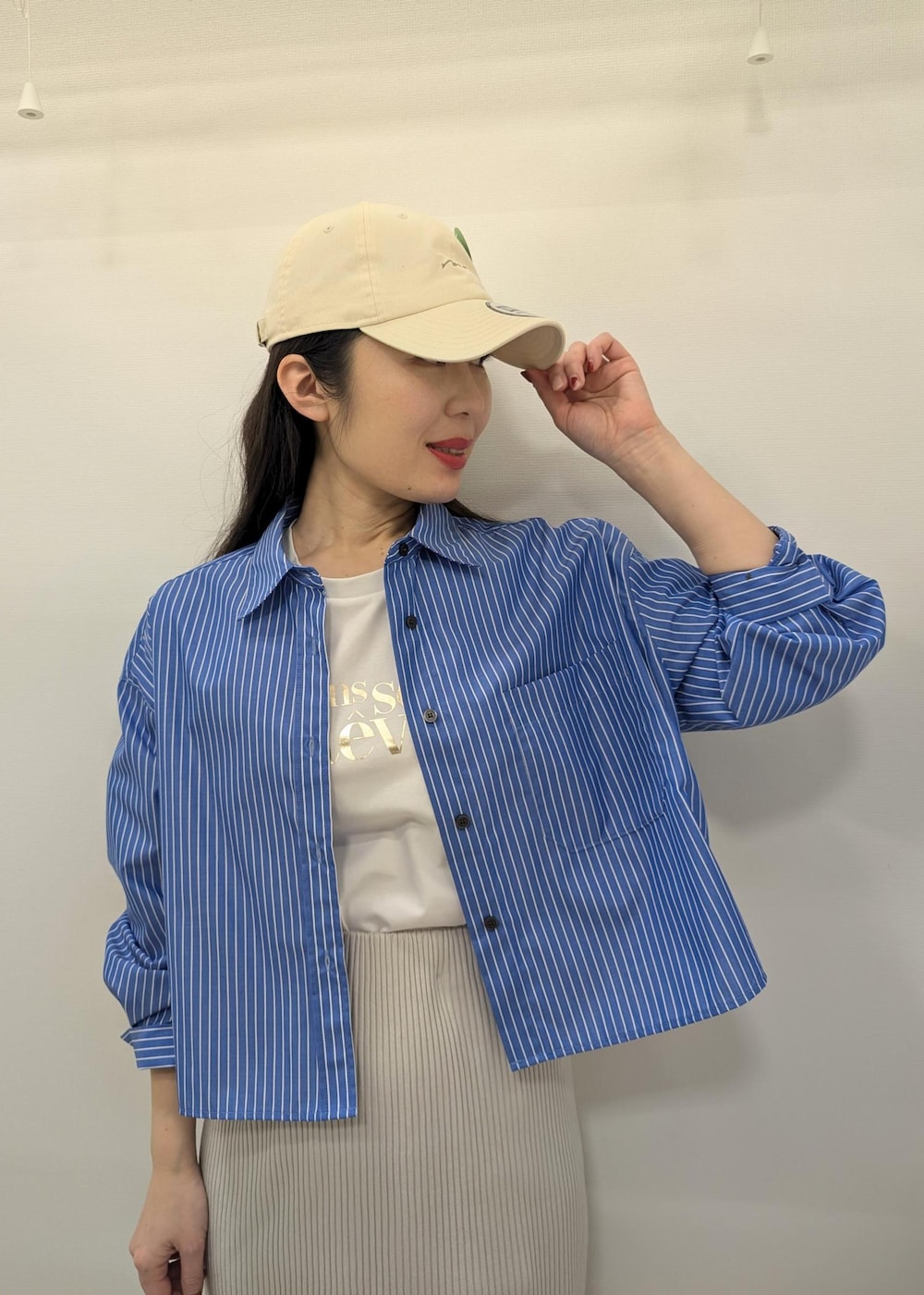 ホワイト系のTシャツ/カットソー、グレー系のスカート、ブルー系のシャツ/ブラウスを着用したレディースの春コーディネートの5枚目の写真