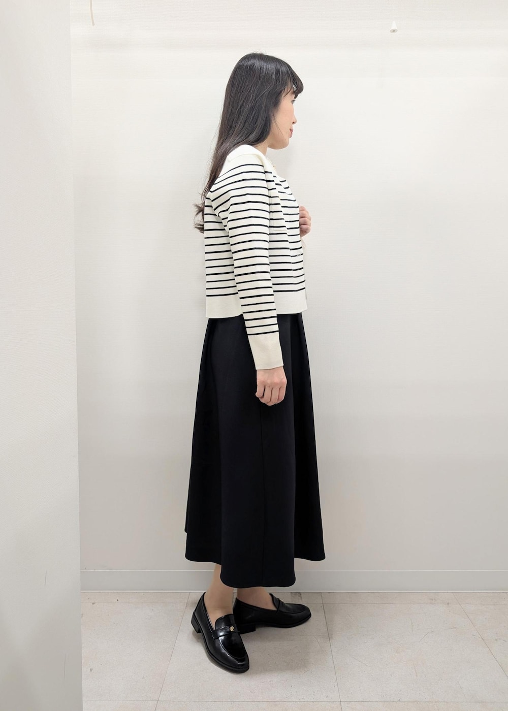 ブラック系のローファー、ブラック系のトートバッグ、ホワイト系のカーディガン/ボレロを着用したレディースの春コーディネートの3枚目の写真