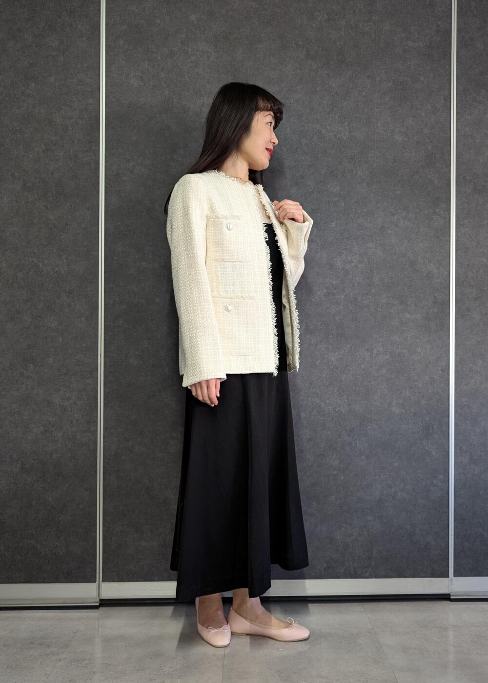 ホワイト系のTシャツ/カットソー、ブラック系のドレス、ホワイト系のノーカラージャケットを着用したレディースの冬コーディネートの2枚目の写真