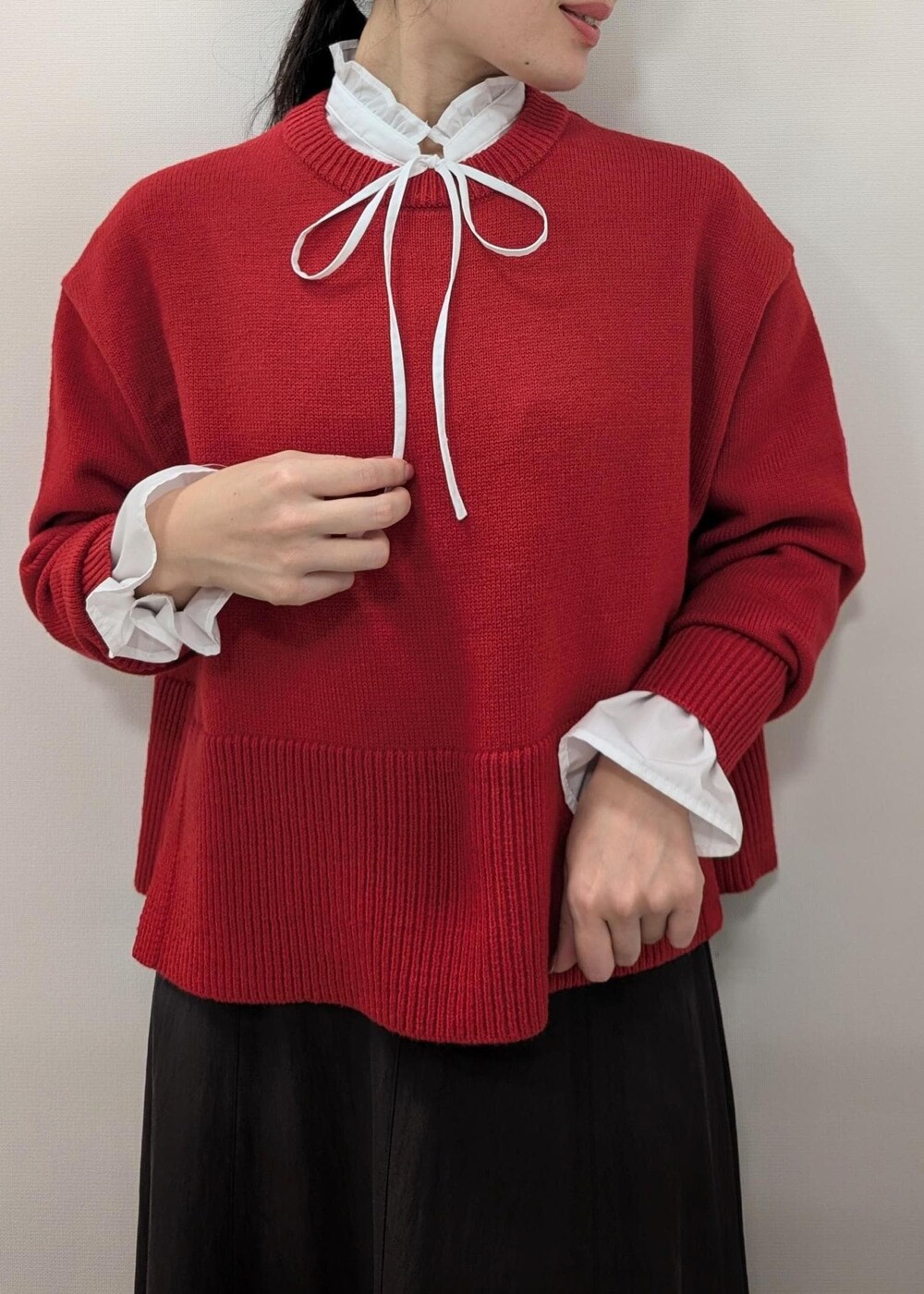 レッド系のニット/セーター、グレー系のスカート、ベージュ系のショルダーバッグを着用したレディースの秋コーディネートの6枚目の写真