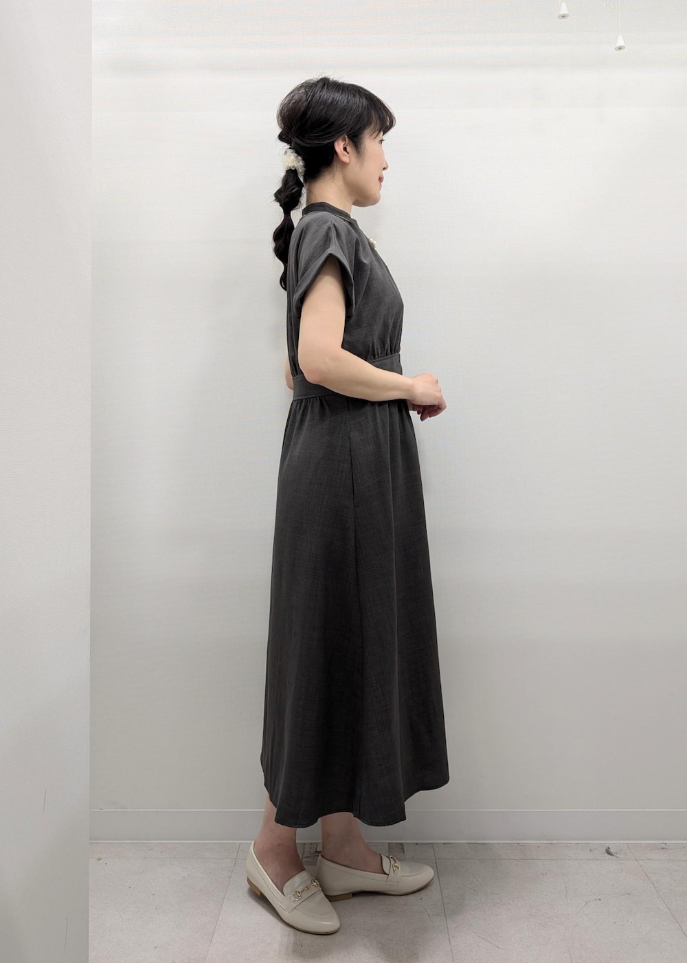 グレー系のワンピース、ホワイト系のパンプス、ホワイト系のトートバッグを着用したレディースの夏コーディネートの2枚目の写真