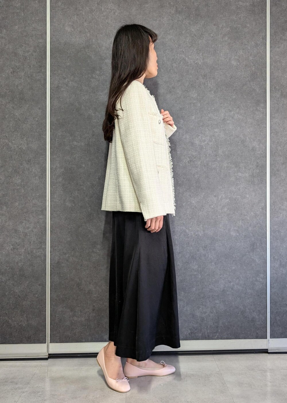 ホワイト系のTシャツ/カットソー、ブラック系のドレス、ホワイト系のノーカラージャケットを着用したレディースの冬コーディネートの3枚目の写真