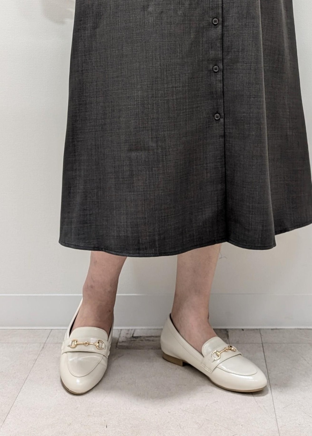 グレー系のワンピース、ホワイト系のパンプス、ホワイト系のトートバッグを着用したレディースの夏コーディネートの7枚目の写真