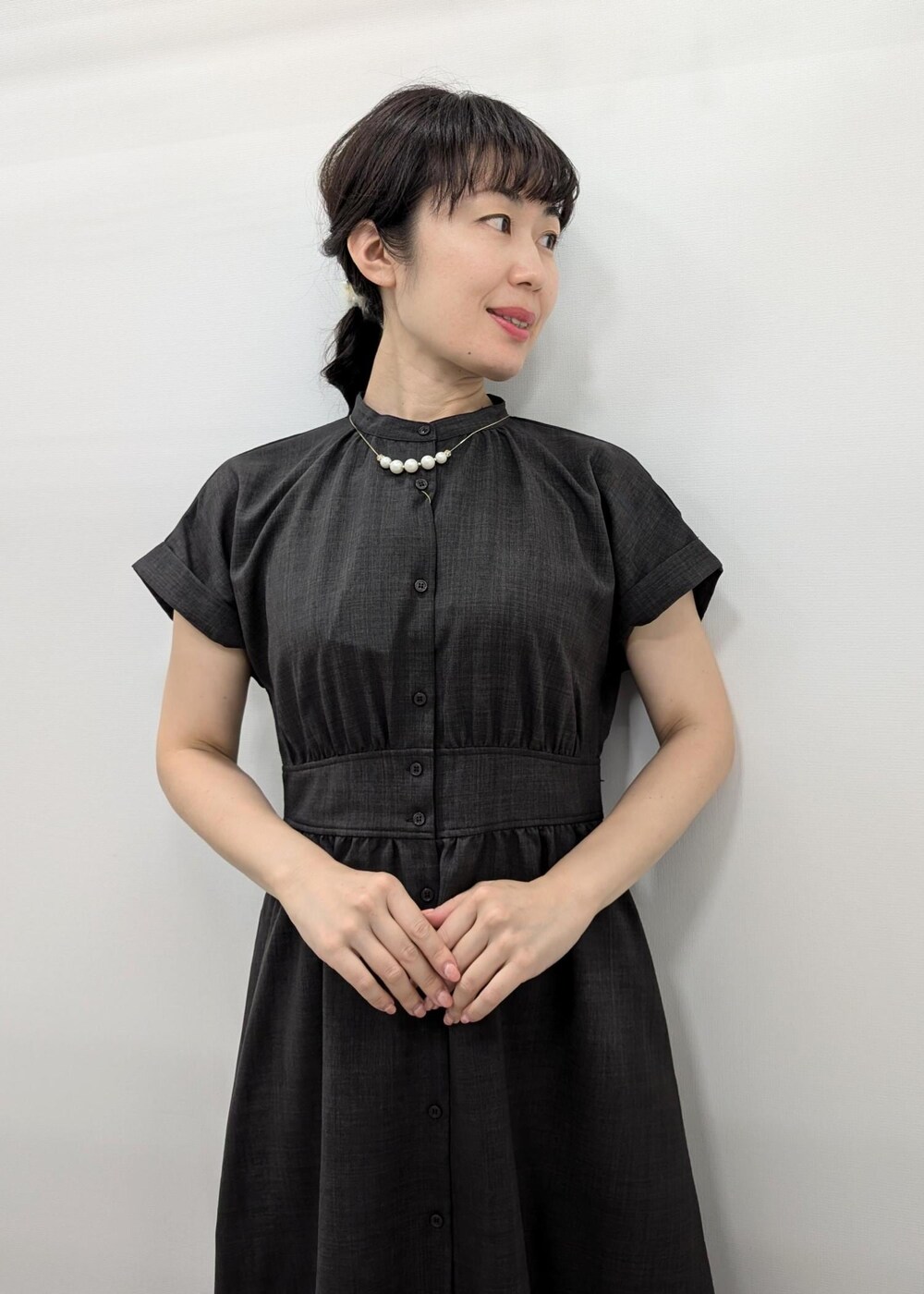 グレー系のワンピース、ホワイト系のパンプス、ホワイト系のトートバッグを着用したレディースの夏コーディネートの5枚目の写真