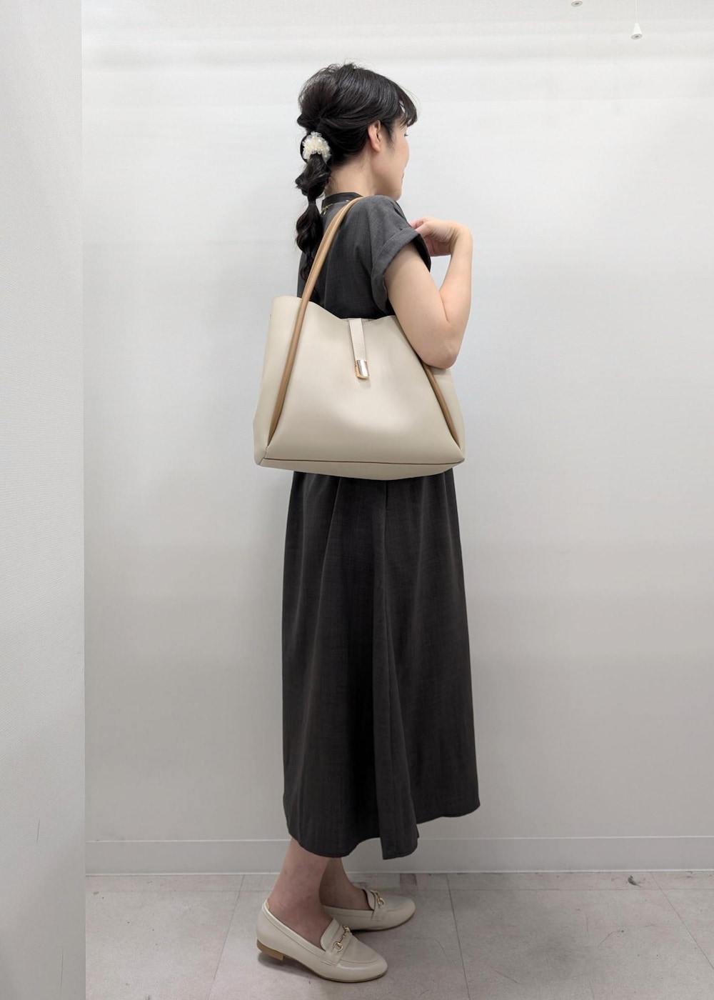 グレー系のワンピース、ホワイト系のパンプス、ホワイト系のトートバッグを着用したレディースの夏コーディネートの6枚目の写真