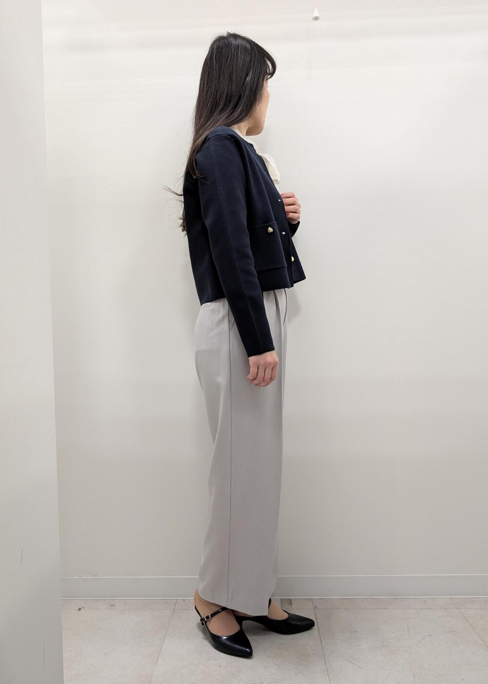 ブラック系のパンプス、ブラック系のトートバッグ、ブルー系のカーディガン/ボレロを着用したレディースの春コーディネートの2枚目の写真
