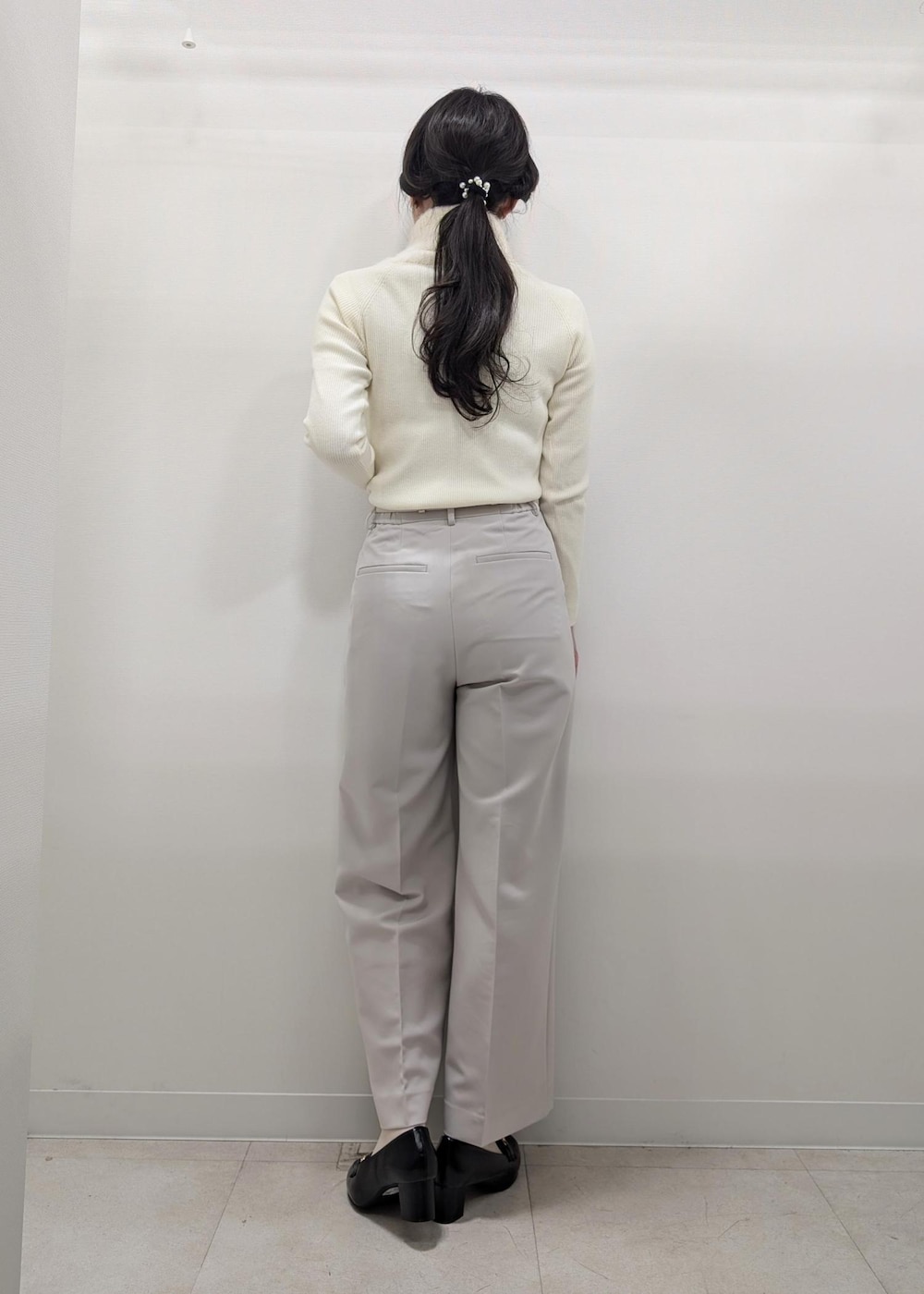 ホワイト系のニット/セーター、ブラック系のテーラードジャケット、ブラック系のショルダーバッグを着用したレディースの冬コーディネートの7枚目の写真