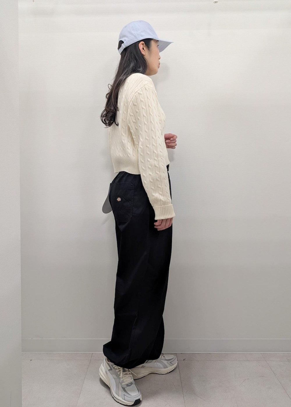 ブラック系のその他パンツ、ホワイト系のニット/セーター、グレー系のスニーカーを着用したレディースの春コーディネートの2枚目の写真