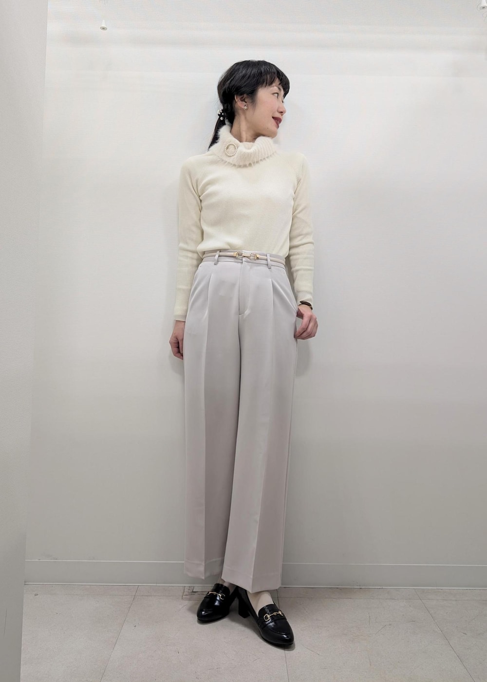 ホワイト系のニット/セーター、ブラック系のテーラードジャケット、ブラック系のショルダーバッグを着用したレディースの冬コーディネートの5枚目の写真