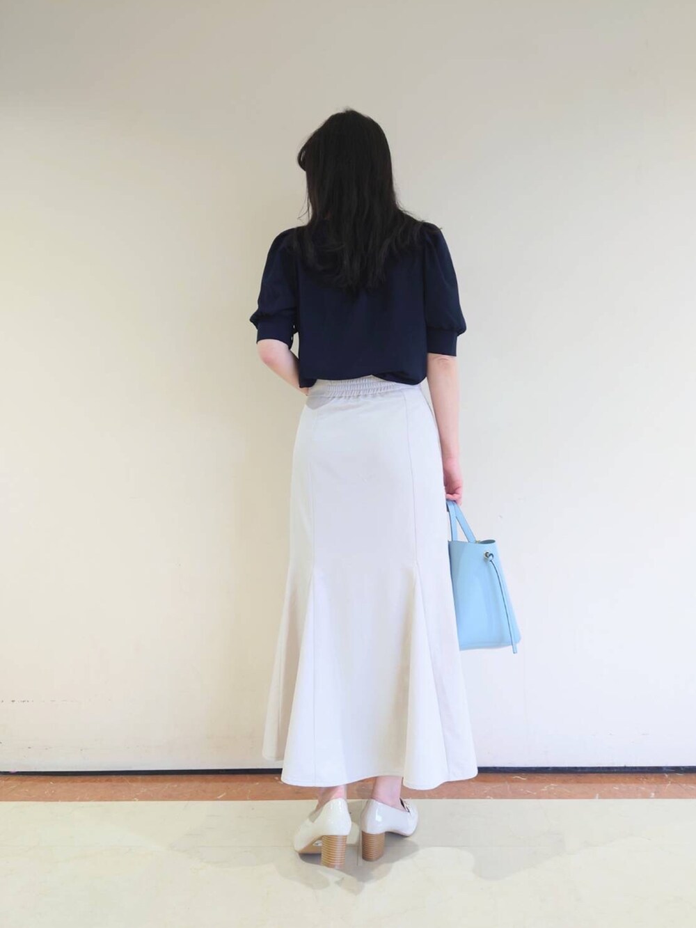 ブルー系のシャツ/ブラウス、ベージュ系のスカート、ホワイト系のローファーを着用したレディースの春コーディネートの3枚目の写真