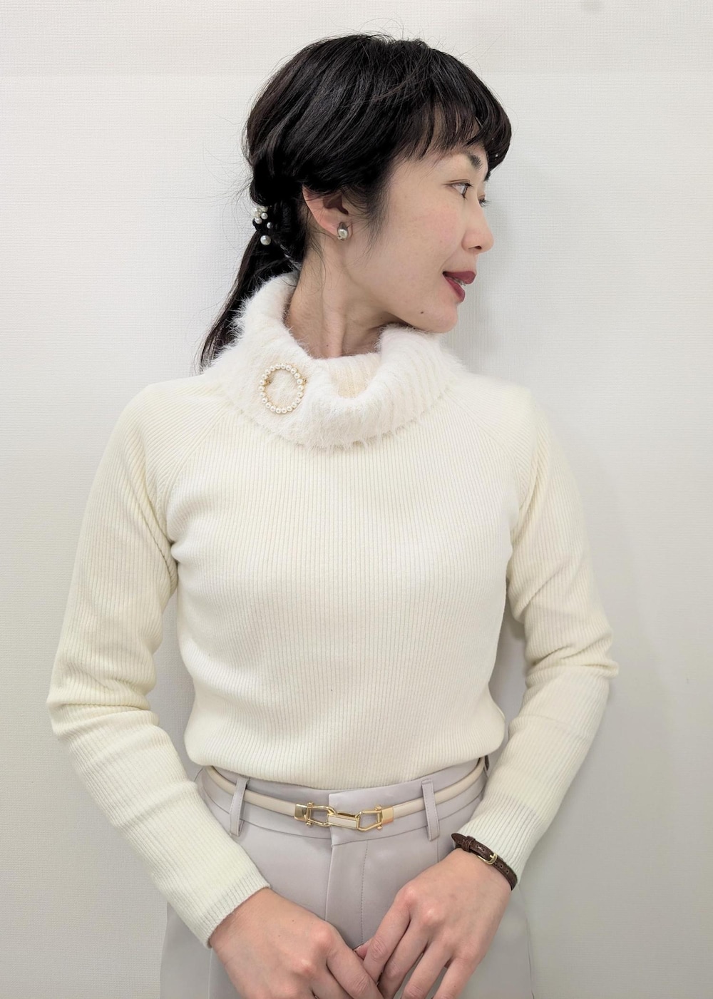 ホワイト系のニット/セーター、ブラック系のテーラードジャケット、ブラック系のショルダーバッグを着用したレディースの冬コーディネートの8枚目の写真