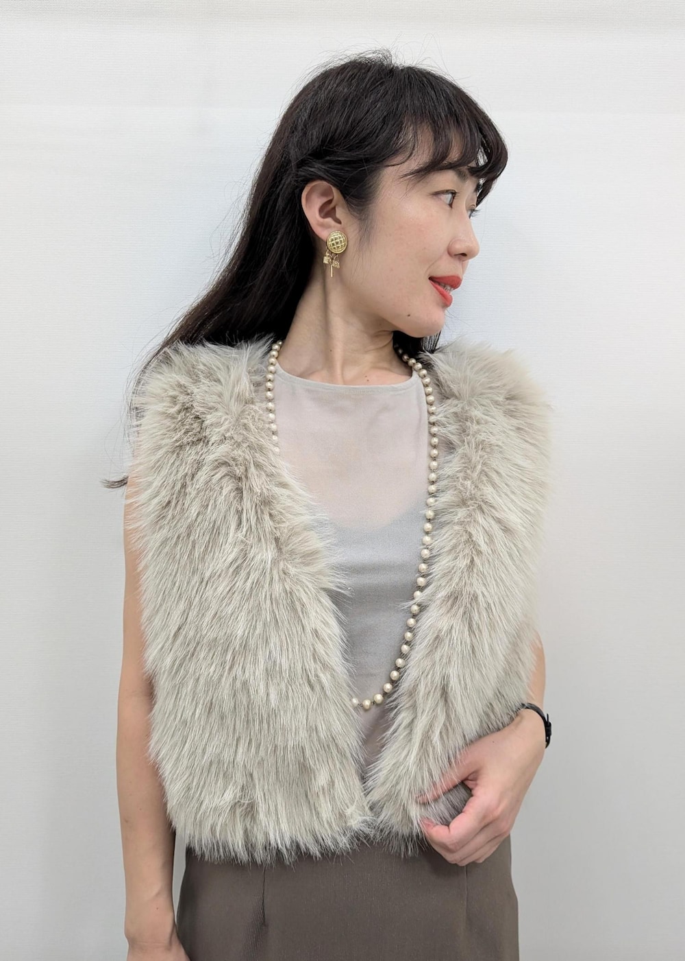 ベージュ系のパンプス、グリーン系のスカート、ホワイト系のトートバッグを着用したレディースの秋コーディネートの5枚目の写真