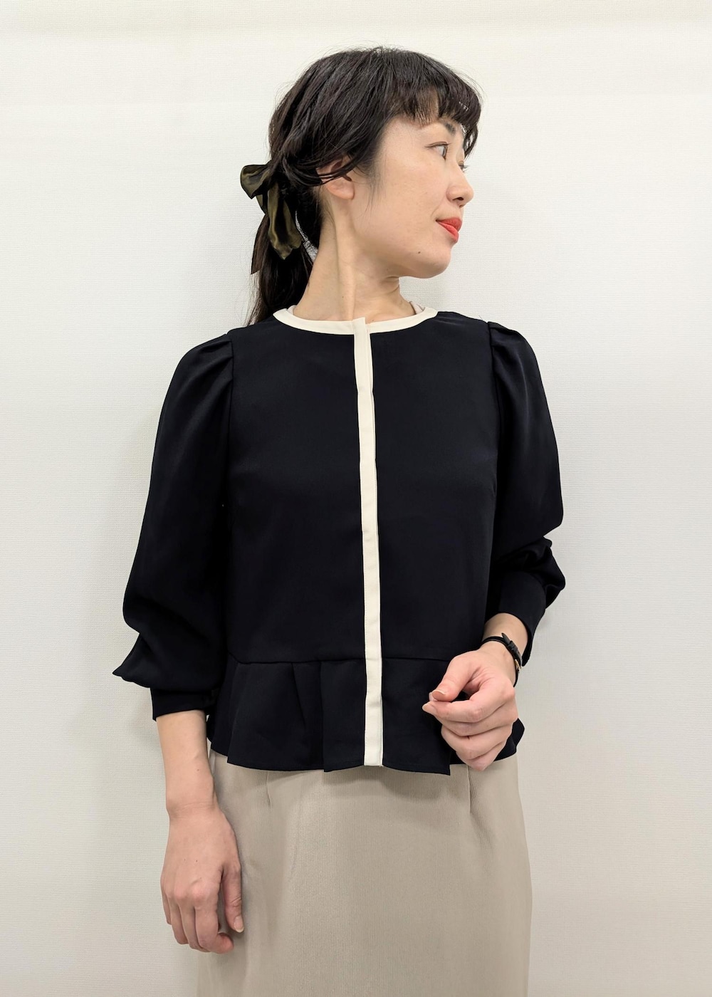 ベージュ系のスカート、ホワイト系のトートバッグ、ブラック系のパンプスを着用したレディースの秋コーディネートの5枚目の写真