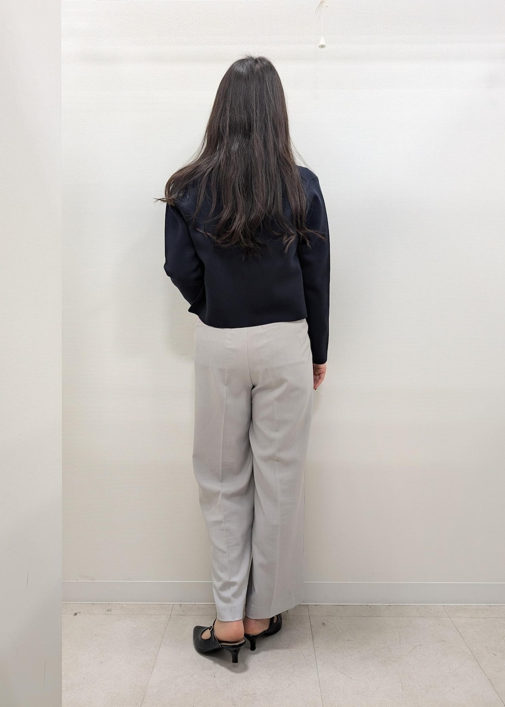 ブラック系のパンプス、ブラック系のトートバッグ、ブルー系のカーディガン/ボレロを着用したレディースの春コーディネートの3枚目の写真