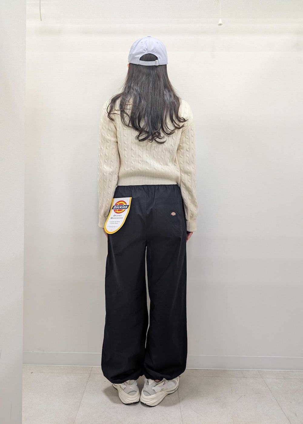 ブラック系のその他パンツ、ホワイト系のニット/セーター、グレー系のスニーカーを着用したレディースの春コーディネートの3枚目の写真