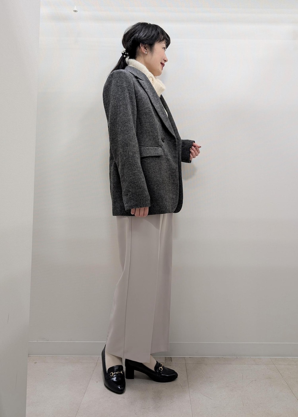 ホワイト系のニット/セーター、ブラック系のテーラードジャケット、ブラック系のショルダーバッグを着用したレディースの冬コーディネートの3枚目の写真