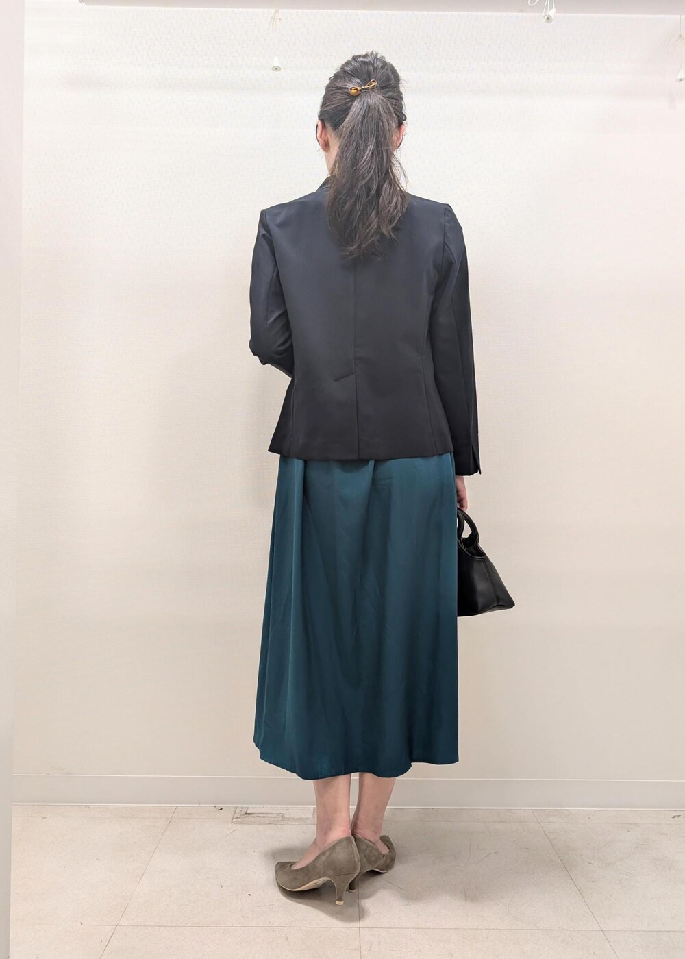 ベージュ系のパンプス、ブルー系のノーカラージャケット、ブラック系のショルダーバッグを着用したレディースの夏コーディネートの6枚目の写真