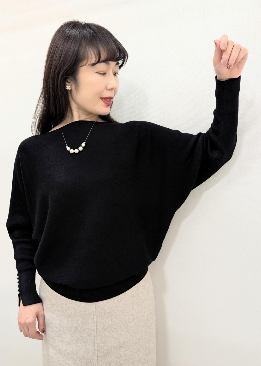 ブラック系のニット/セーター、ブラック系のトートバッグ、ブラック系のパンプスを着用したレディースの秋コーディネートの6枚目の写真