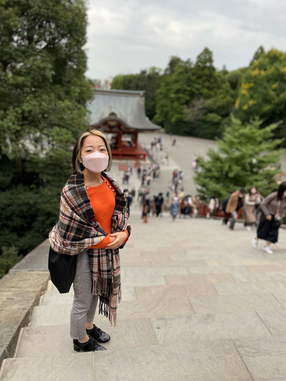 オレンジ系のニット/セーター、ブラック系のショルダーバッグ、その他のその他パンツを着用したレディースの春コーディネートの2枚目の写真