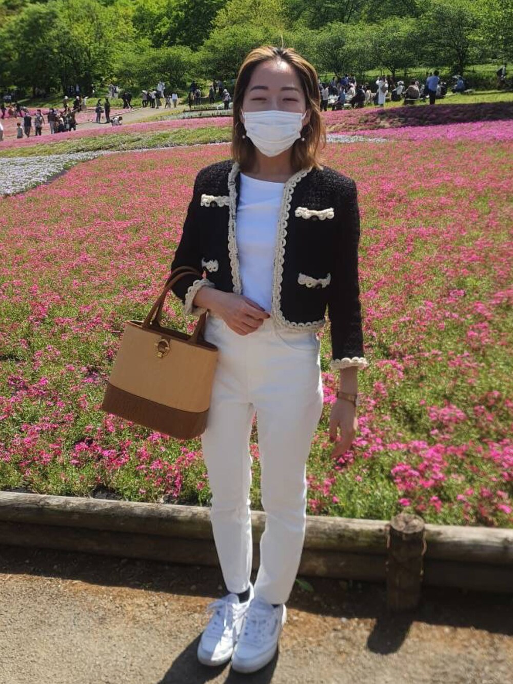 ブラック系のジャケット/アウター、ホワイト系のスニーカー、ホワイト系のパンツを着用したレディースの夏コーディネートの2枚目の写真