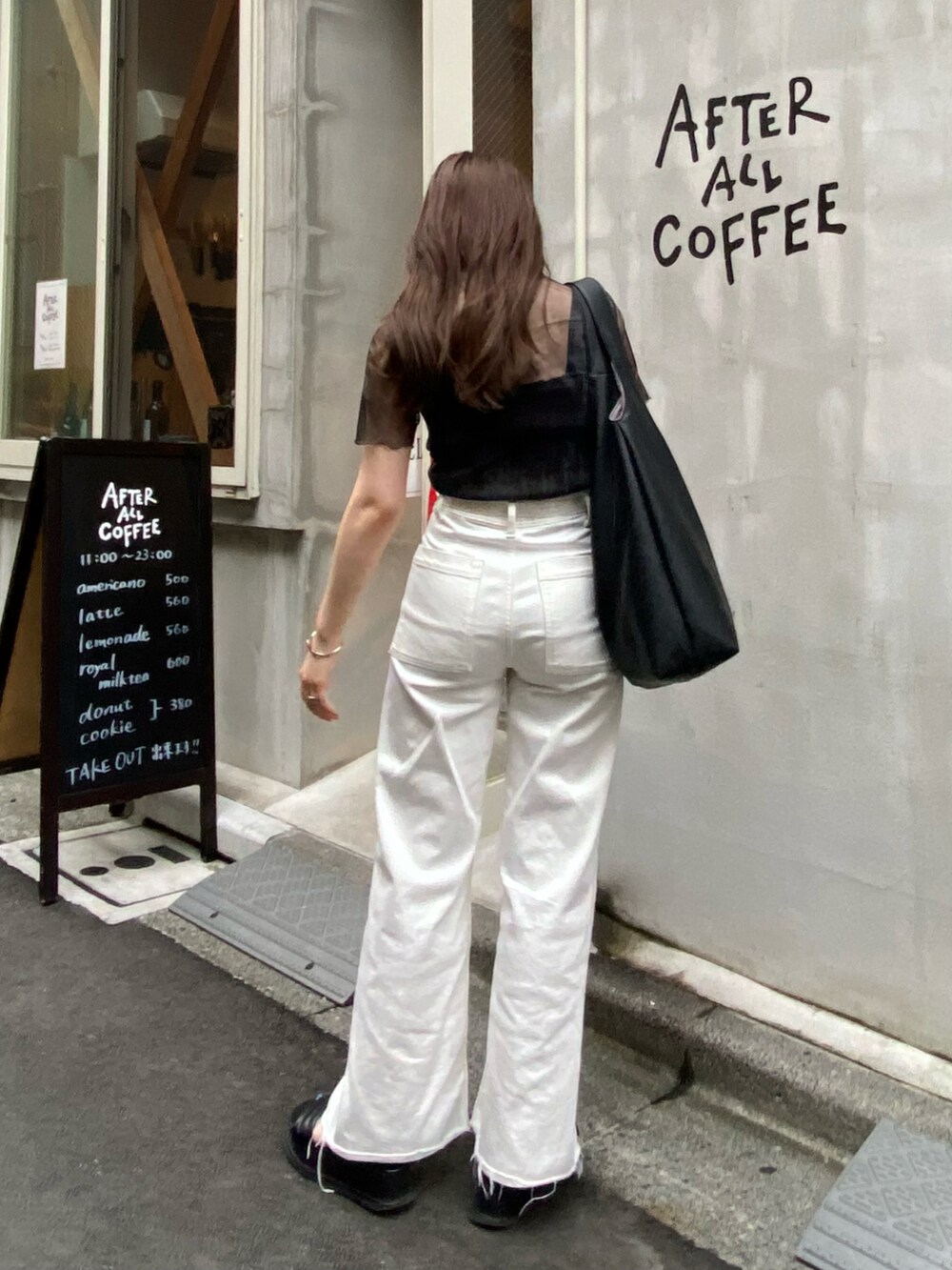 ホワイト系のデニムパンツ、ブラック系のキャミソール、ブラック系のTシャツ/カットソーを着用したレディースの秋コーディネートの2枚目の写真