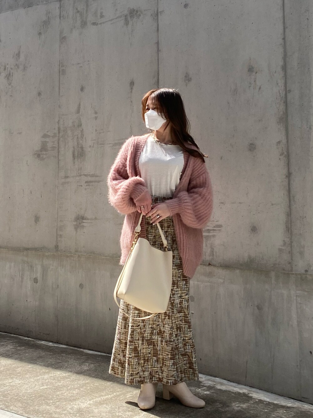 ピンク系のカーディガン/ボレロ、ベージュ系のスカート、ホワイト系のTシャツ/カットソーを着用したレディースの春コーディネートの2枚目の写真