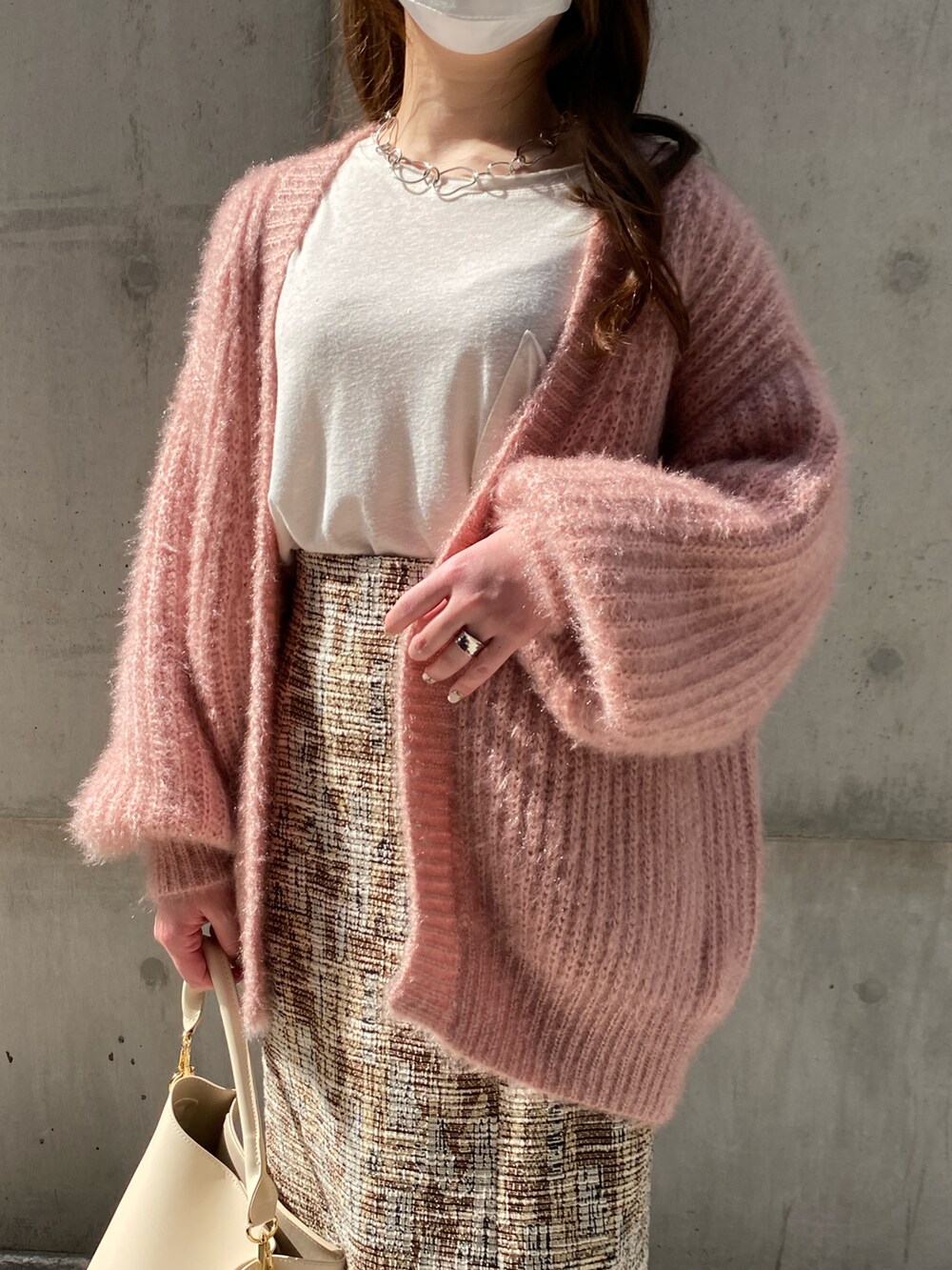 ピンク系のカーディガン/ボレロ、ベージュ系のスカート、ホワイト系のTシャツ/カットソーを着用したレディースの春コーディネートの5枚目の写真