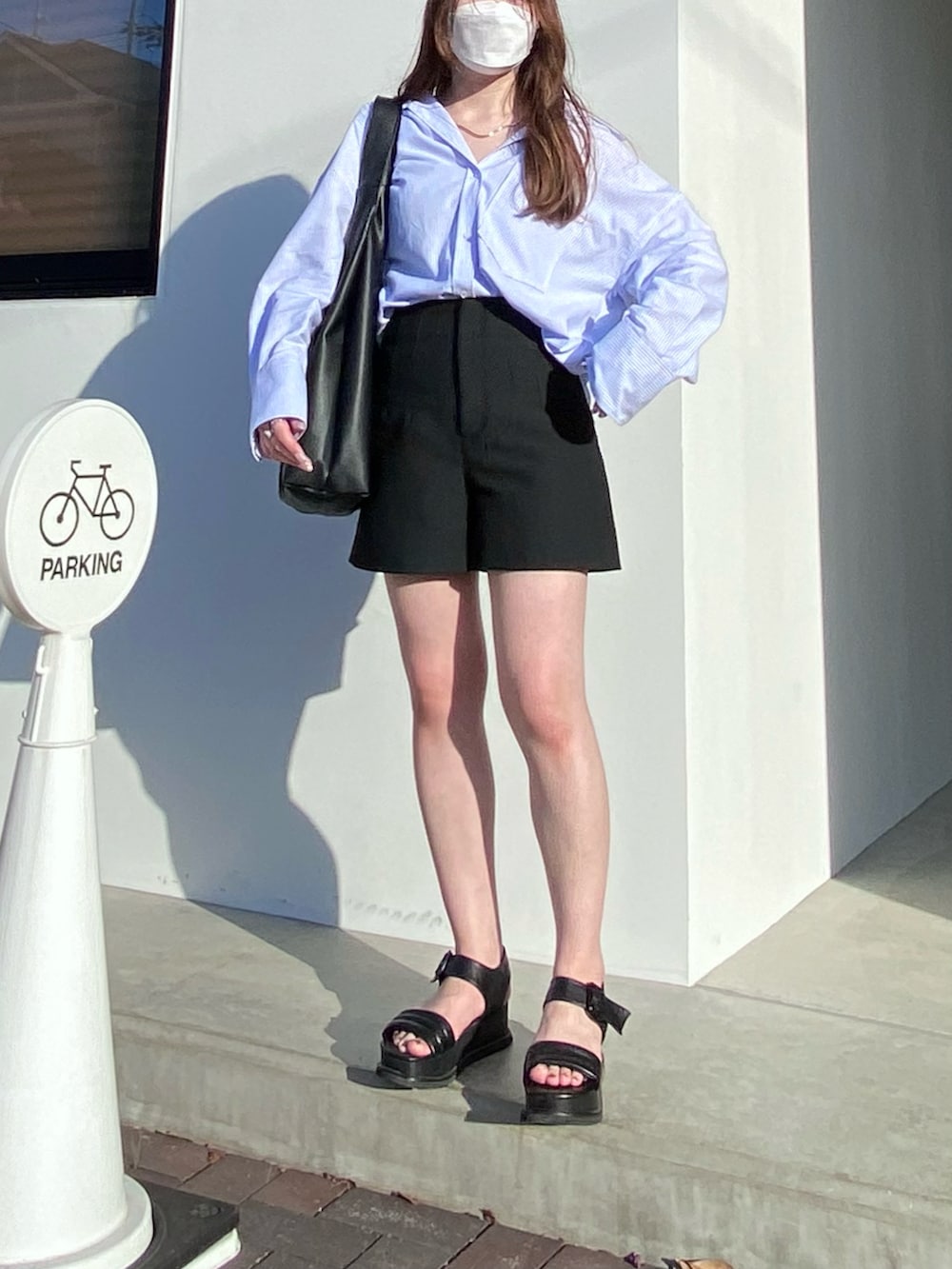 ブラック系のサンダル、ブラック系のパンツ、ブラック系のトートバッグを着用したレディースの夏コーディネートの2枚目の写真