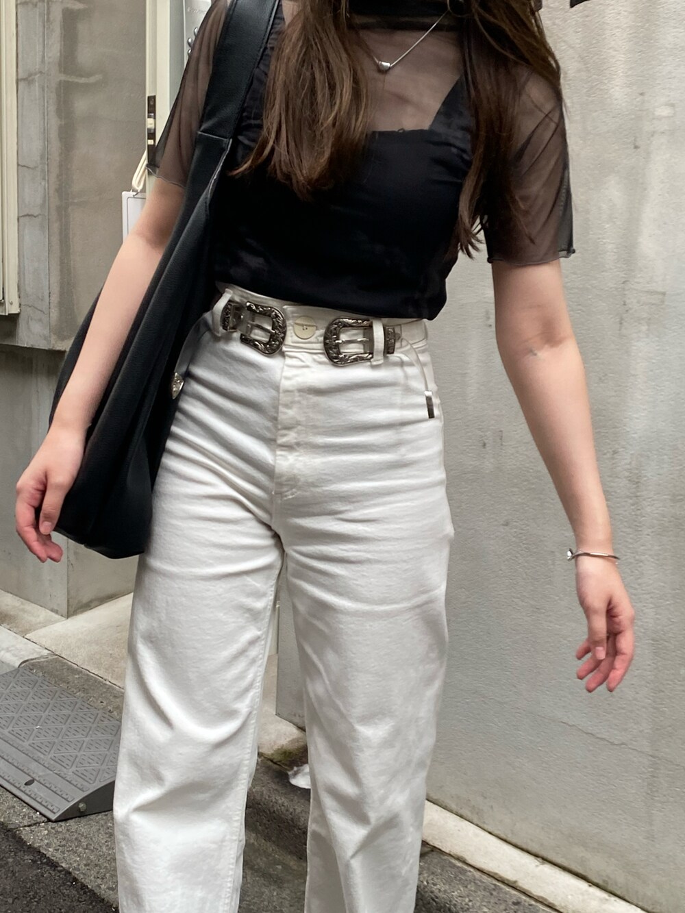 ホワイト系のデニムパンツ、ブラック系のキャミソール、ブラック系のTシャツ/カットソーを着用したレディースの秋コーディネートの3枚目の写真