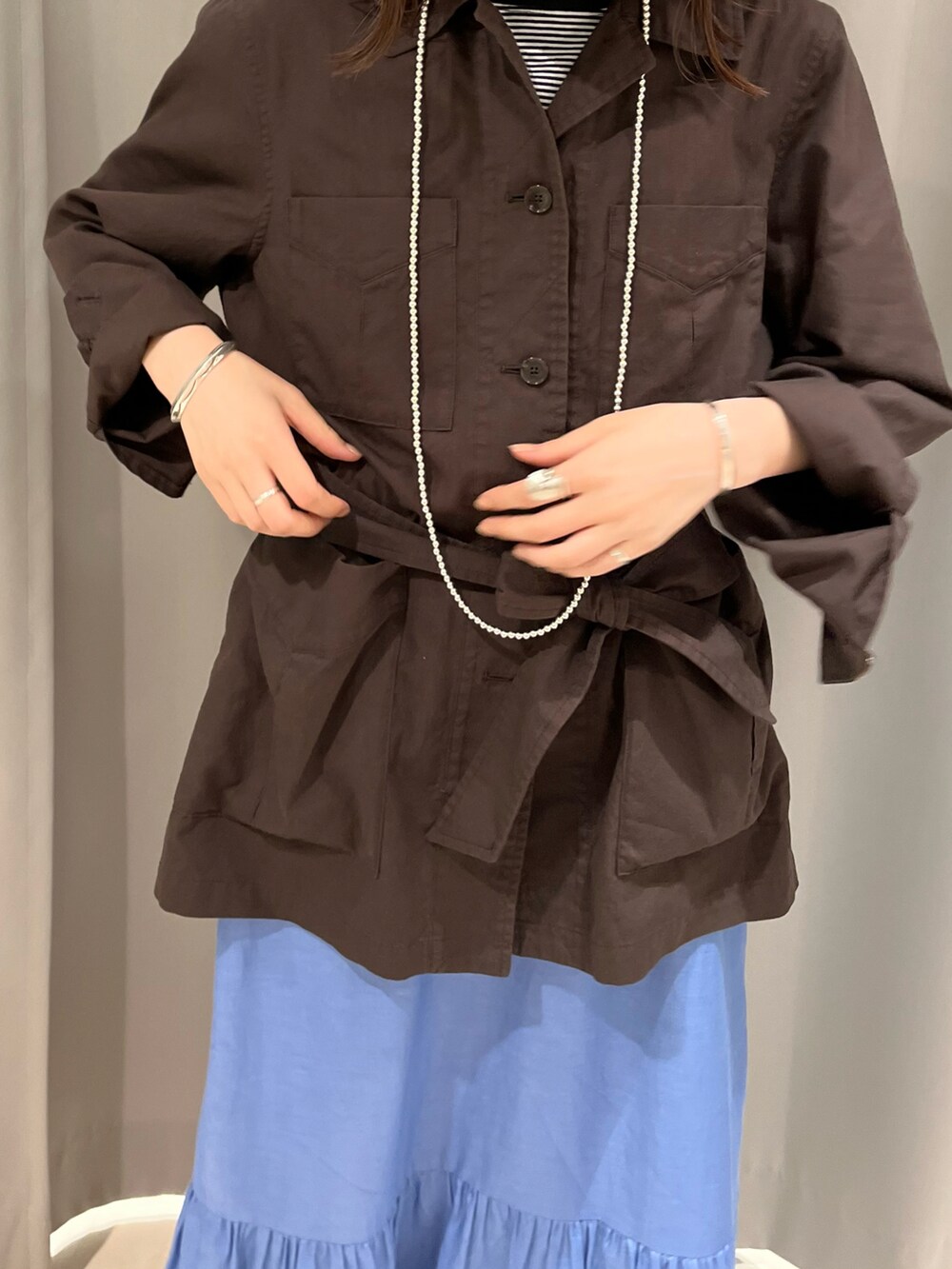 グレー系のジャケット/アウター、ブルー系のスカート、ホワイト系のその他を着用したレディースの春コーディネートの2枚目の写真