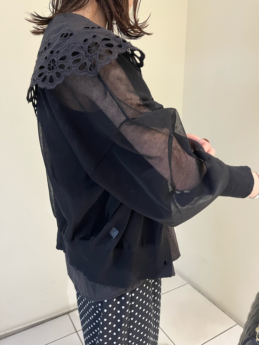 ブラック系のその他パンツ、ゴールド系のパンプス、ブラック系のショルダーバッグを着用したレディースの春コーディネートの2枚目の写真