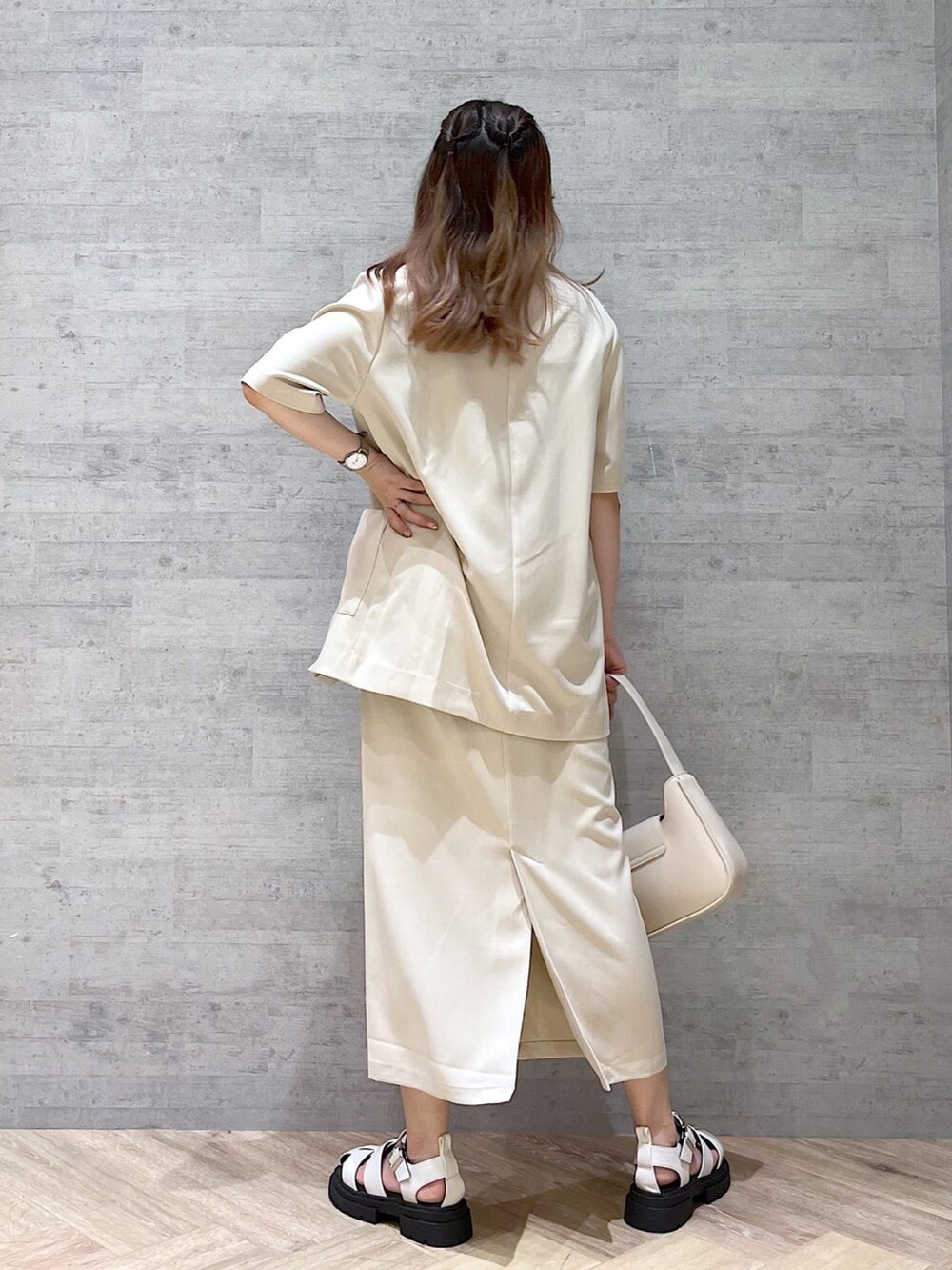 ホワイト系のサンダル、ブラック系のタンクトップ、ベージュ系のテーラードジャケットを着用したレディースの夏コーディネートの2枚目の写真