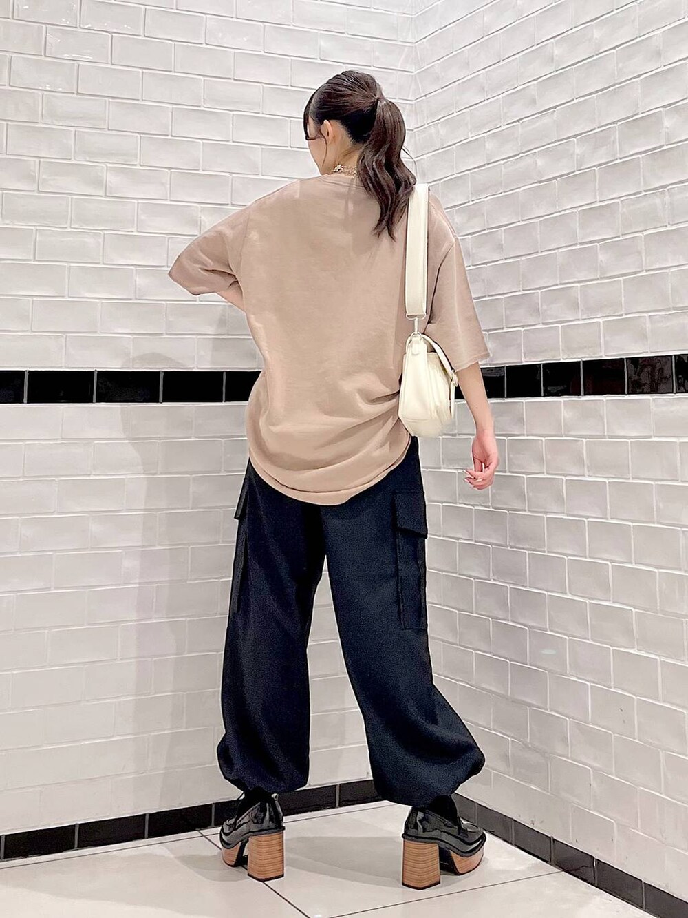 ブラウン系のTシャツ/カットソー、ブラック系のカーゴパンツ、ブラック系のローファーを着用したレディースの秋コーディネートの5枚目の写真