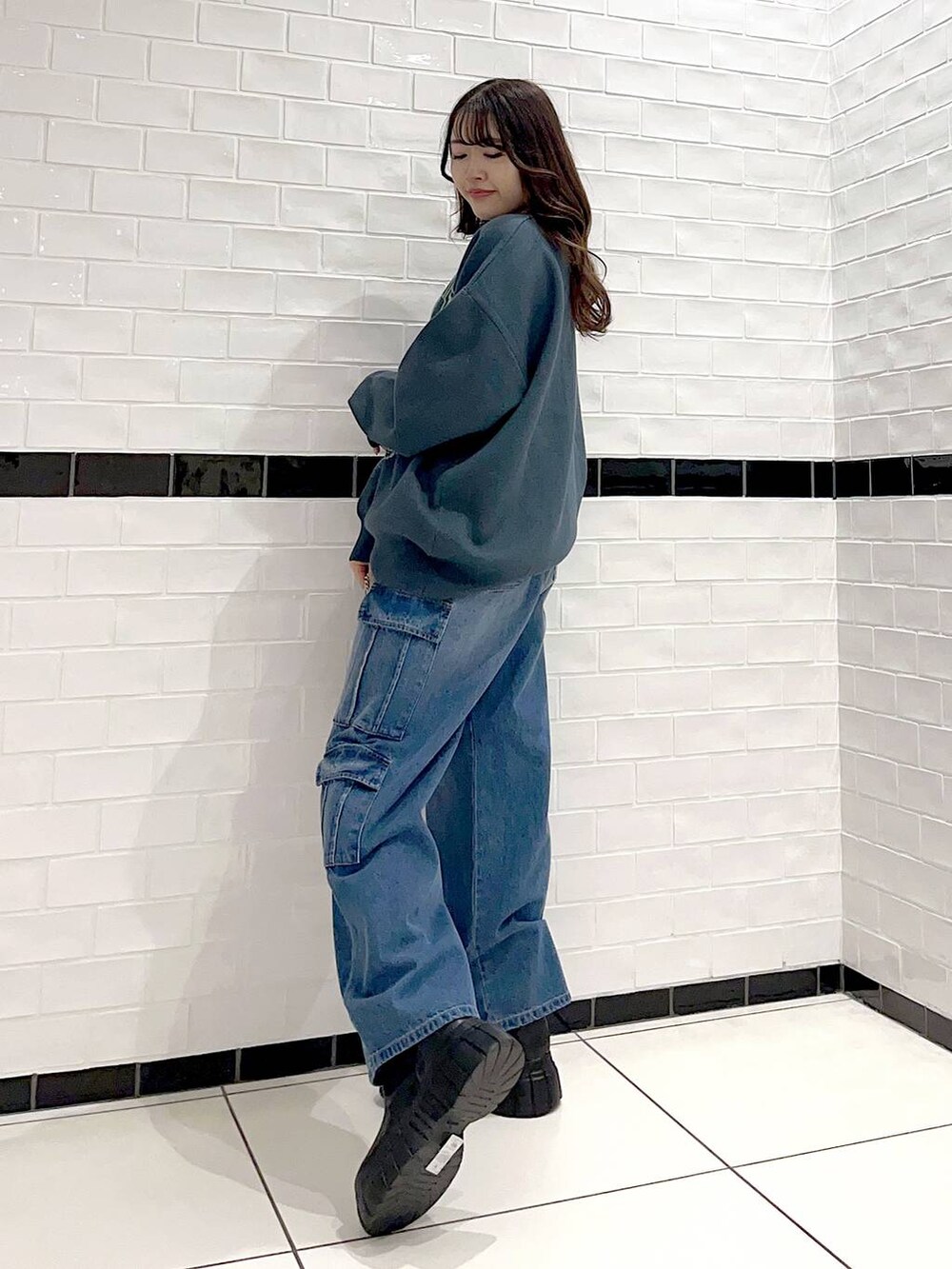 ブラック系のブーツ、シルバー系のショルダーバッグ、グリーン系のニット/セーターを着用したレディースの冬コーディネートの4枚目の写真