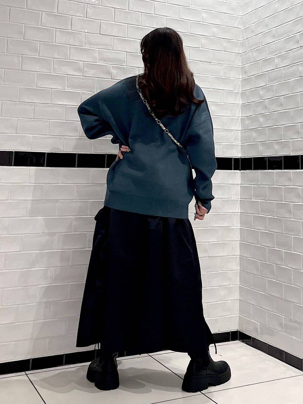 ブラック系のブーツ、シルバー系のショルダーバッグ、グリーン系のニット/セーターを着用したレディースの冬コーディネートの5枚目の写真